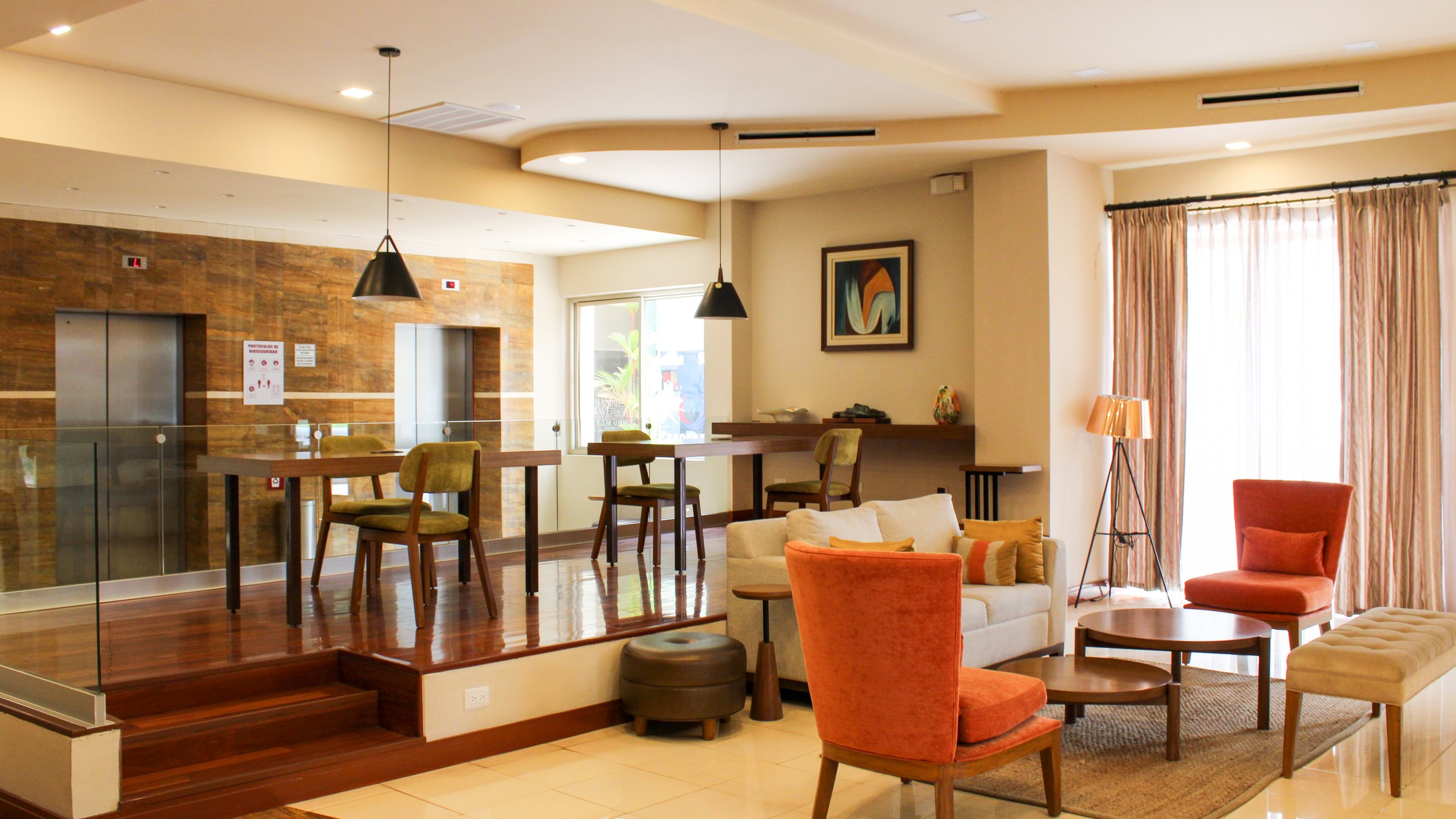 Lobby de Suites Las Palmas en San Salvador: sala de estar con sillones, mesas de trabajo y piso de mármol